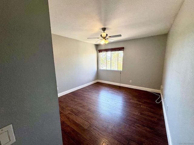 empty room featuring dark hardwood / wood-style flooring, a textured ceiling, and ceiling fan