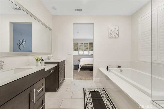 bathroom with tile patterned flooring, vanity, and a tub