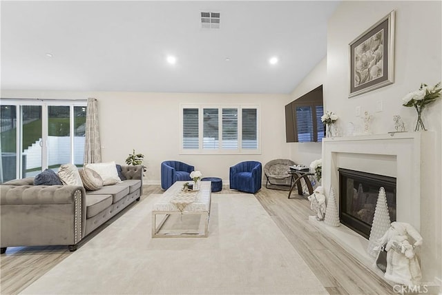 living room featuring vaulted ceiling and light wood-type flooring