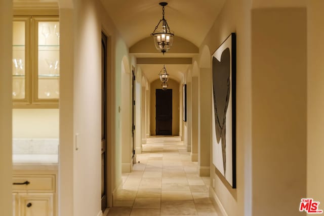 hall featuring light tile patterned floors and an inviting chandelier