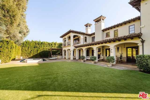 rear view of house with a patio area and a yard