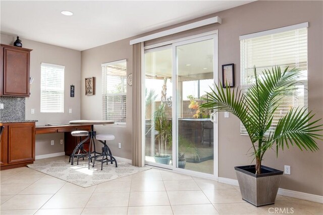 doorway to outside with light tile patterned flooring