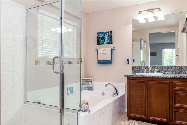 bathroom featuring vanity and shower with separate bathtub