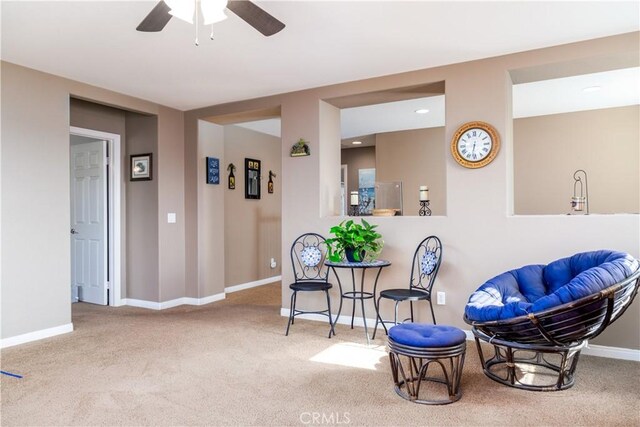 sitting room with ceiling fan and carpet