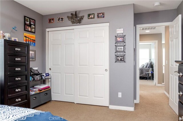 bedroom featuring light colored carpet and a closet