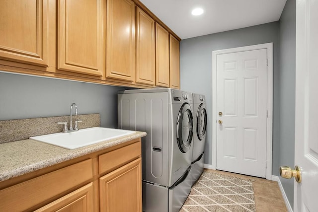 washroom with light tile patterned flooring, cabinets, washer and dryer, and sink