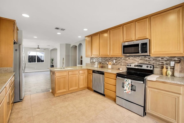 kitchen featuring ceiling fan, decorative backsplash, sink, appliances with stainless steel finishes, and light tile patterned floors