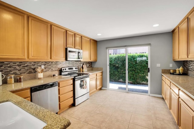 kitchen featuring light tile patterned floors, decorative backsplash, appliances with stainless steel finishes, and light stone counters