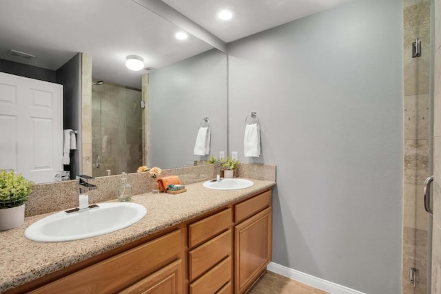 bathroom featuring a shower with shower door, vanity, and tile patterned flooring