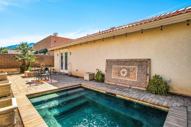 view of pool featuring a jacuzzi, french doors, and a patio