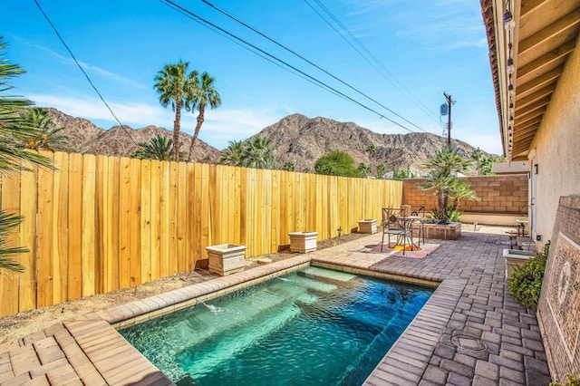 view of pool featuring a patio area and a mountain view