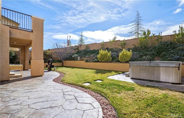 view of yard with a balcony, a hot tub, and a patio