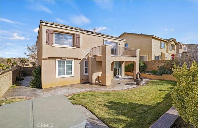 back of house featuring a balcony, a yard, and a patio