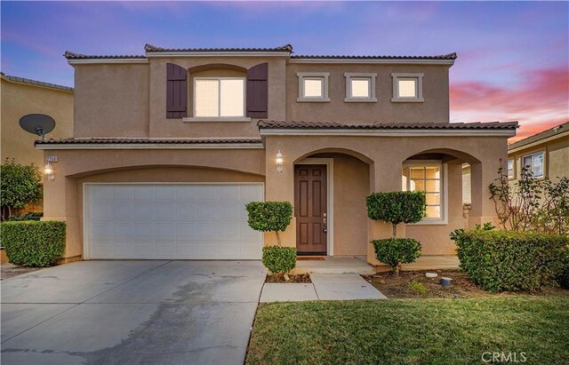 mediterranean / spanish-style house with a garage