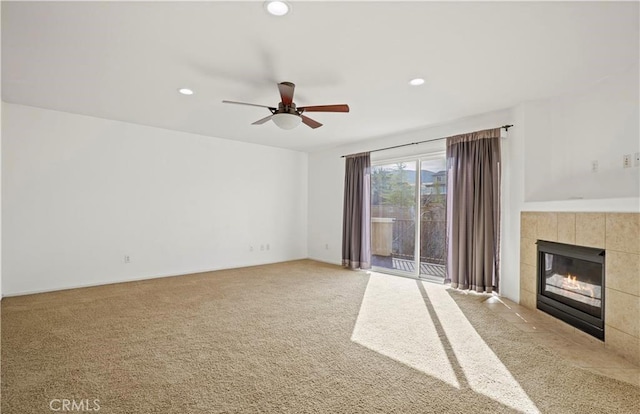 unfurnished living room with ceiling fan, carpet, and a fireplace