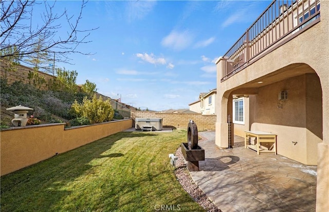 view of yard with a hot tub, a balcony, and a patio