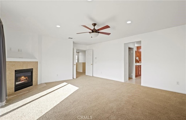 unfurnished living room featuring light carpet, ceiling fan, and a fireplace