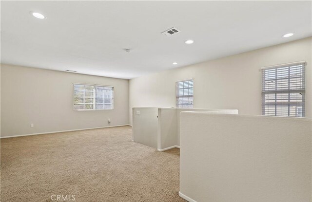 empty room featuring plenty of natural light and light carpet