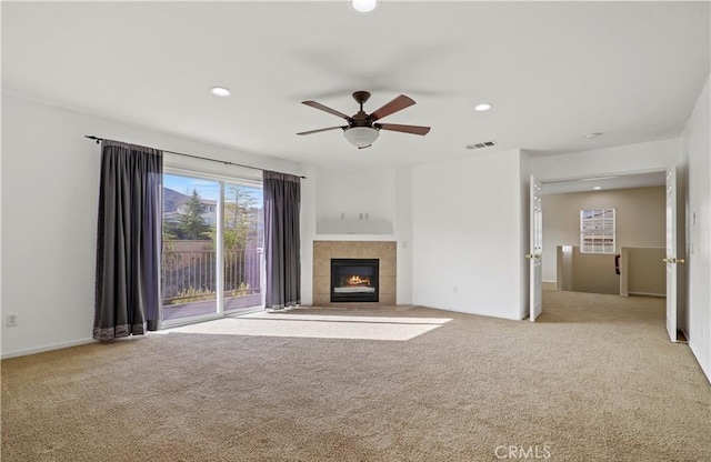 unfurnished living room featuring ceiling fan, light carpet, and a fireplace