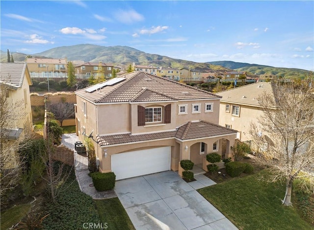 mediterranean / spanish house featuring a garage and a mountain view