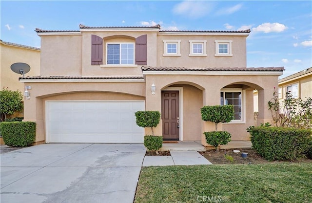 mediterranean / spanish-style home featuring stucco siding, an attached garage, driveway, and a tile roof