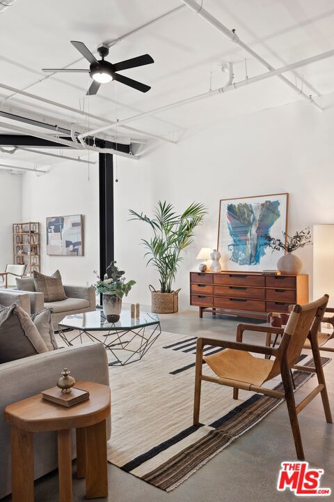 living room with ceiling fan and concrete floors