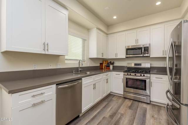 kitchen featuring stainless steel appliances, white cabinetry, and sink