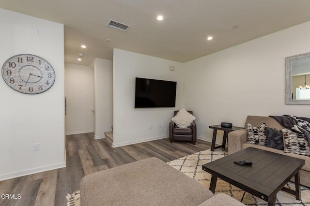 living room featuring dark wood-type flooring and a notable chandelier