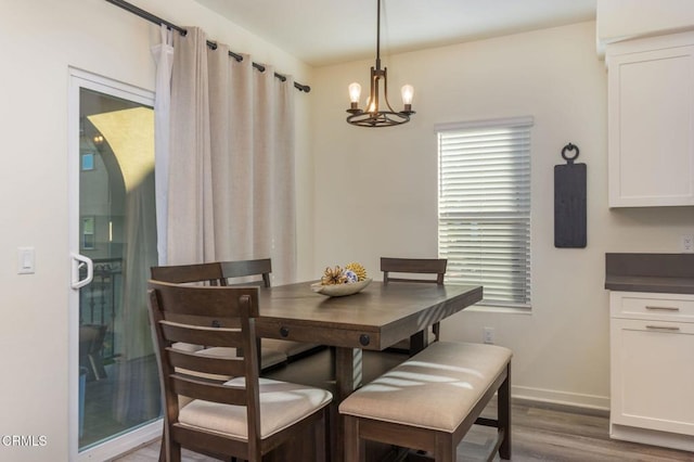 dining room featuring dark hardwood / wood-style flooring and an inviting chandelier