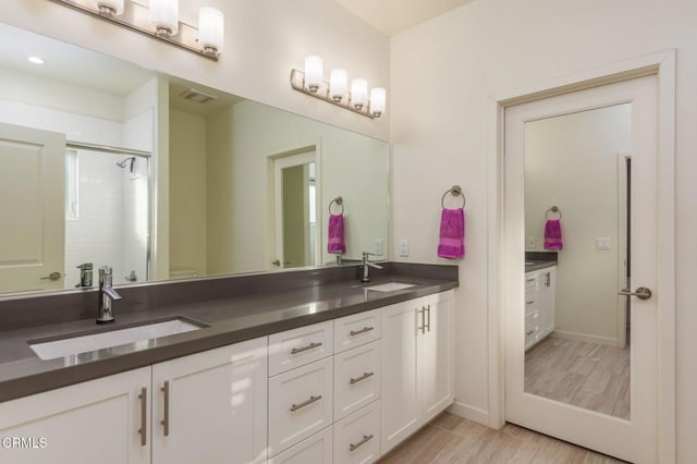 bathroom featuring walk in shower and vanity