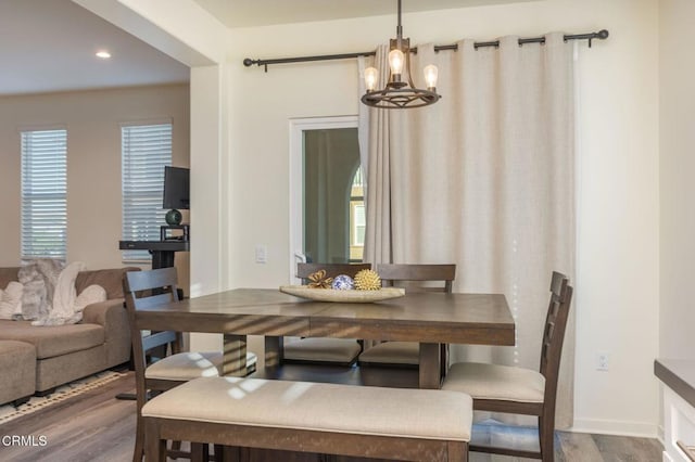 dining area featuring wood-type flooring and a notable chandelier