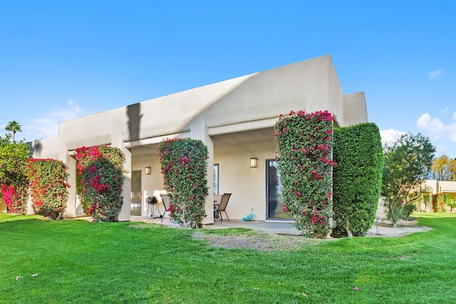 rear view of house with a patio area and a yard