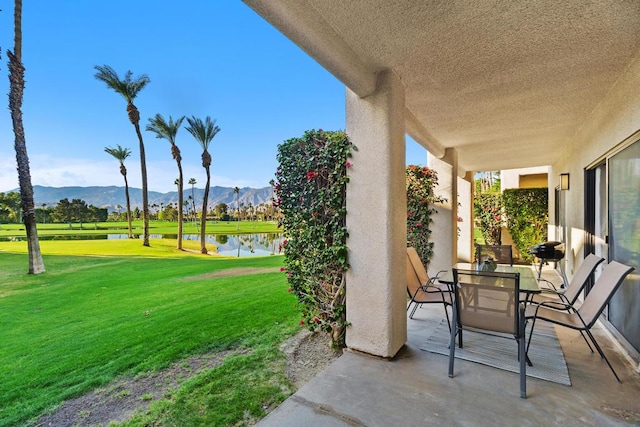 view of patio / terrace with a water and mountain view