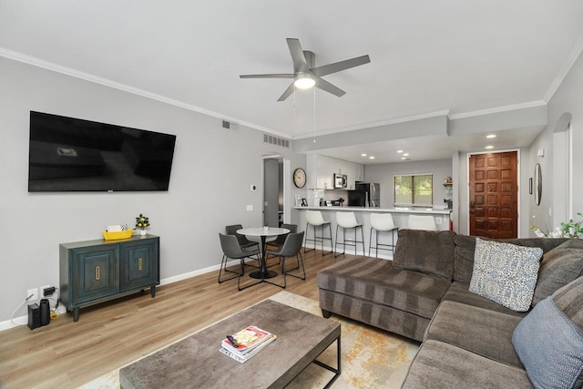 living room with ceiling fan, light hardwood / wood-style flooring, and crown molding