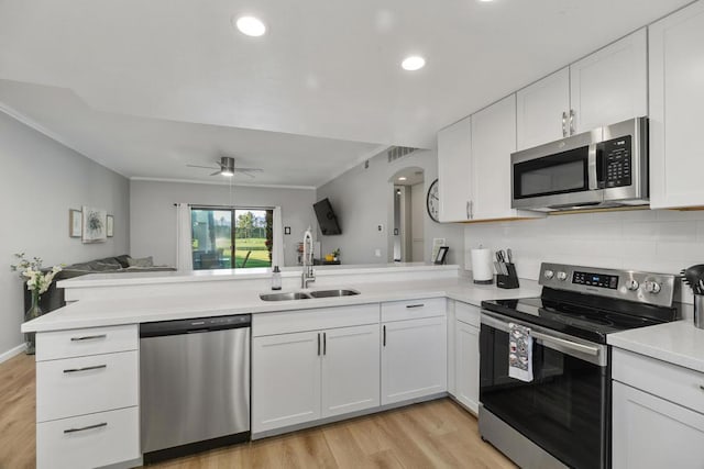 kitchen featuring kitchen peninsula, ceiling fan, appliances with stainless steel finishes, white cabinets, and sink