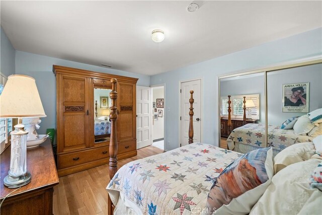 bedroom with light wood-type flooring and a closet