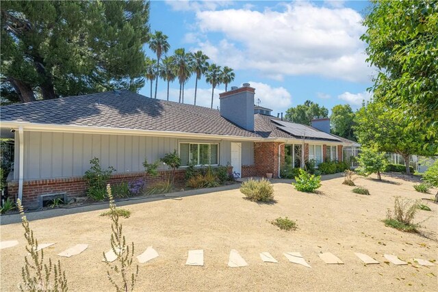 ranch-style house featuring solar panels