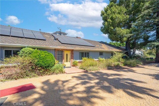 view of front of property featuring solar panels