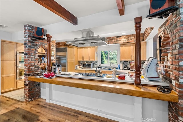 kitchen with kitchen peninsula, light hardwood / wood-style flooring, stainless steel appliances, light brown cabinetry, and island range hood