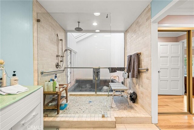 bathroom featuring a shower with shower door, hardwood / wood-style floors, and vanity