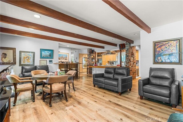 living room with light hardwood / wood-style flooring and beamed ceiling