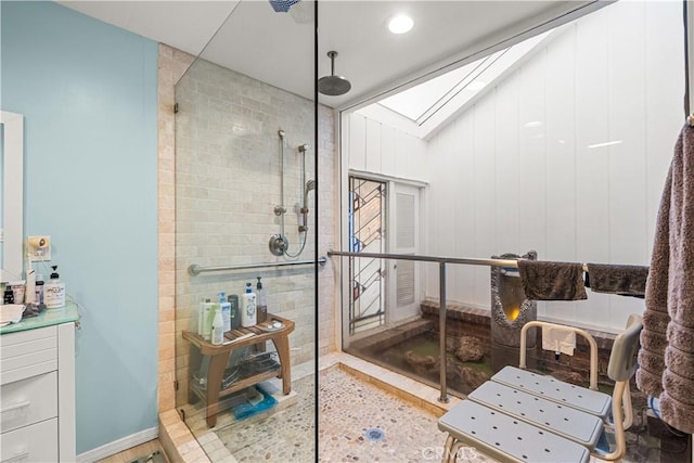 bathroom featuring a skylight and tiled shower