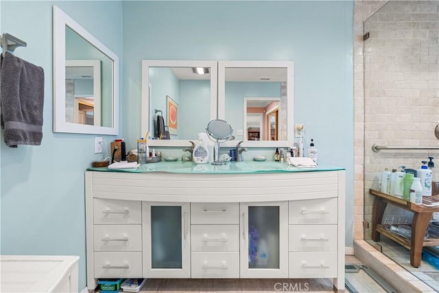 bathroom featuring a shower and vanity