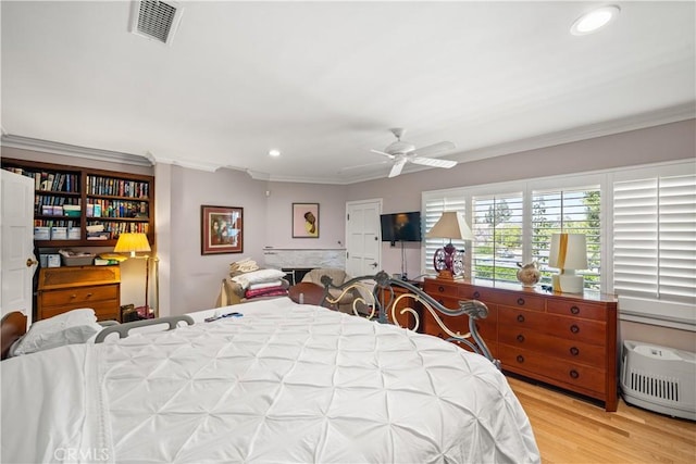 bedroom featuring ceiling fan, ornamental molding, and light hardwood / wood-style floors