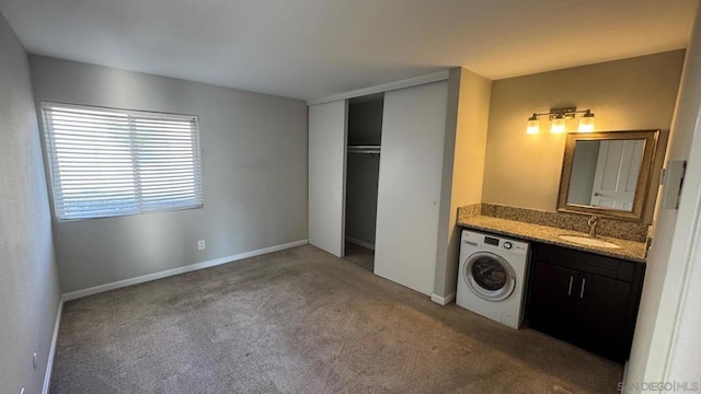 clothes washing area featuring carpet floors, washer / clothes dryer, and sink