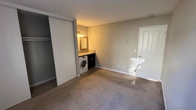 clothes washing area featuring carpet floors and washer / dryer