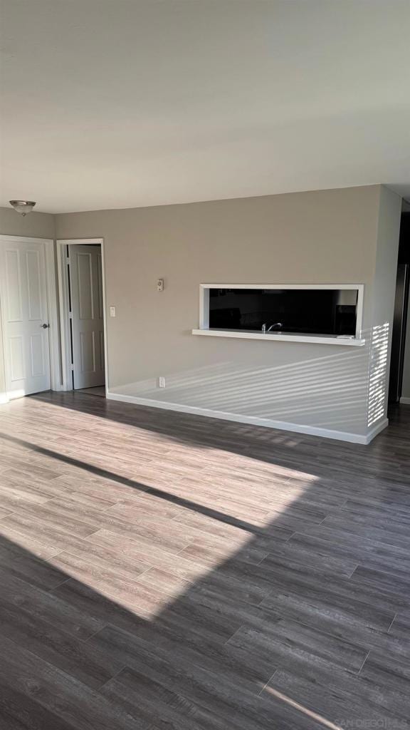 unfurnished living room with dark hardwood / wood-style floors