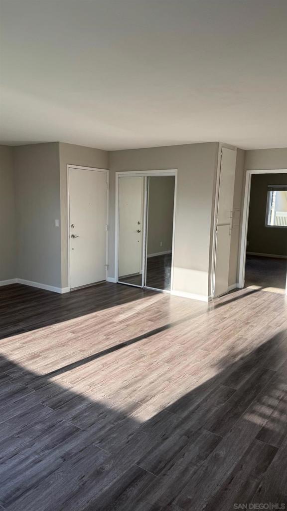 empty room with dark wood-type flooring