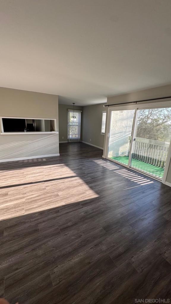 unfurnished living room with dark wood-type flooring