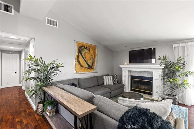 living room with vaulted ceiling, a premium fireplace, and dark hardwood / wood-style floors